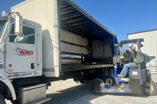 Redkey Express employee working a forklift getting freight off of a truck.