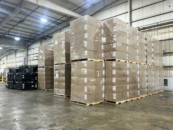 Stacks of boxes that go high up into a warehouse.