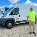 Redkey Express employee standing in front of one of their branded vehicles.
